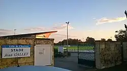 Portail avec un terrain de football en fond.