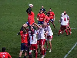 Des joueurs de rugby se disputent le ballon après avoir joué une touche.