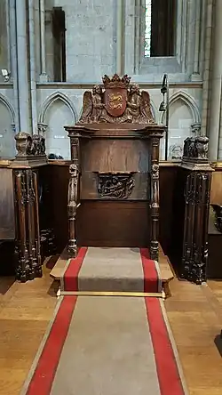 Photo de la stalle de l'archevêque surmonté d'un blason aux armes de Normandie porté par deux anges