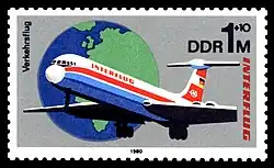 Timbre gris, représentant un Il-62 venant vers nous, et un globe terrestre en arrière-plan.