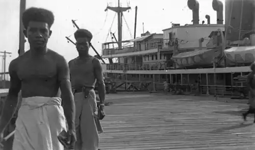 Cargo en attente de déchargement et Papous portant le sarong (1946).