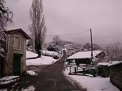 Maison et dépendance le long d'une route sous la neige.