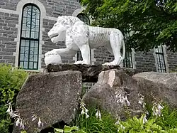 Lion de ciment sur le côté nord-est de l'église de Sainte-Thècle façonné par le curé Maxime Masson.