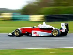 Monoplace rouge, blanche et noire, vue de profil.