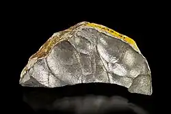 Coupe d'une fraction de nodule AsSb oxydé en surface extraite de la mine Bambolla, Moctezuma , Sonora, Mexique. Taille : 5.8 x 3.0 x 1.6 cm. Musée de l'Université de l'Arizona.