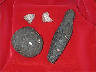 Outils lithiques oldowayens de Cooper D. Marteau lithique, objet en schiste, éclats en quartz.