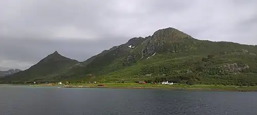 Côte Ouest de Stormolla depuis Øyhellsundet, avec les villages de Langnes et Øyhell, au pied des montagnes Durmålstinden et Steindalstinden (481 m) et à gauche le pic Hamntinden (460 m).