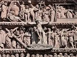 Statue du Christ en croix entourée de nombreuses autres statues réparties sur deux niveaux.