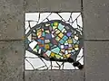 Mosaïque sur le trottoir au no 140