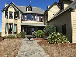 Photo d'une maison avec une sculpture et des arbustes.