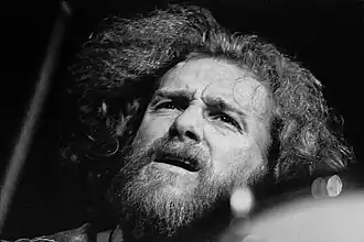 Un homme en concert, l'air inspiré.