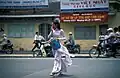 Étudiante traversant la rue, vêtue d'un áo dài (Hô Chi Minh-Ville, 2002)