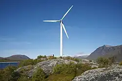 Une éolienne, avec des montagnes en arrière-plan.