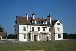 Photographie de Sutton Hoo House, maison blanche à deux étages avec toit rouge.