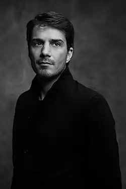 Photo en noir et blanc d'un homme portant un pull noir.