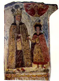 Photo d'une peinture murale montrant une femme portant des vêtements d'une reine et un jeune enfant.