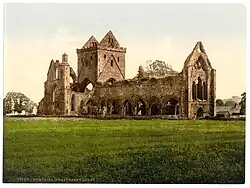 Photographie couleur du dix-neuvième siècle montrant une église partiellement ruinée.