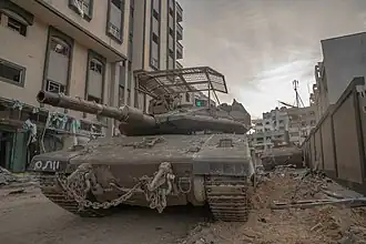 Un Merkava Mk. 4 progressant dans une rue de Gaza, lors de l'opération Swords of Iron, en novembre 2023.