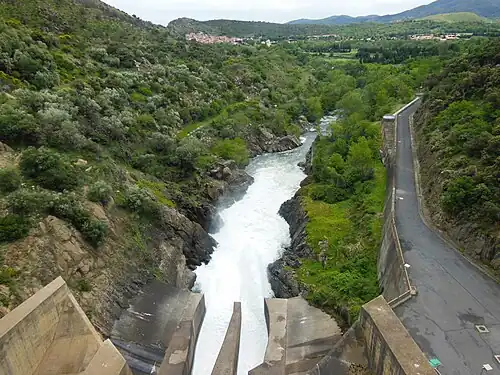 La Têt jaillit de la base du barrage de Vinça, avec Rodès au-delà.