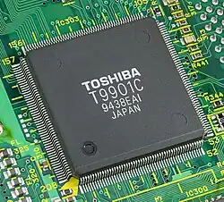 Le controleur T9901 de Toshiba. Ce boîtier de circuit intégré contient en particulier de la mémoire vive, un oscillateur à fréquence variable ou des conducteurs pour les imprimantes et les micros.