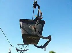 Une benne vue de profil, du côté du système de verrouillage-déverrouillage en position de marche.