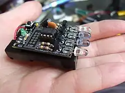 Petite télécommande sans boitier, posée sur la paume d'une main