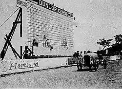 Photo d'un tableau d'affichage géant devant lequel passe une voiture.