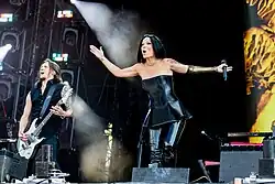 Image d'un guitariste et d'une chanteuse brune jouant sur scène