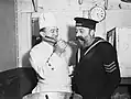 Le cuisinier du navire donne à un marin un avant-goût du Christmas pudding de 1940 à terre à HMS&nbsp;Cochrane (novembre 1940).