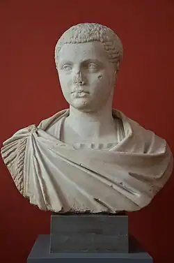 Buste sculpté d'un jeune homme imberbe aux cheveux courts et en toge, regardant vers la gauche.