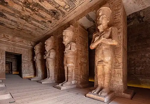 Salle hypostyle du grand temple : les piliers en colosses déifiés portent le pschent, la double couronne de l'Égypte.