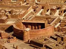 Vue d'un théâtre sur une maquette, avec à l'arrière un temple.