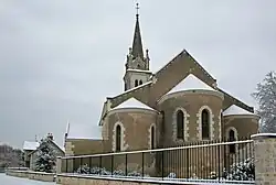 Photographie en couleurs d'un édifice religieux sous la neige.