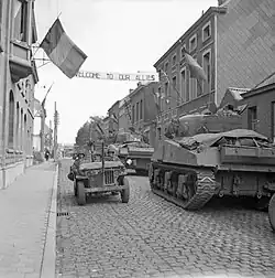 Dans une rue d’Antoing, le 3 septembre 1944, chars Sherman de la 5e&nbsp;division blindée des Gardes de l’armée de terre du Royaume-Uni croisant une jeep américaine durant les opérations de libération de la Belgique.