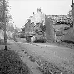 Chars M4 Sherman des forces armées britanniques circulant dans Escoville le 18 juillet 1944, pendant l'opération Goodwood de la bataille de Normandie.