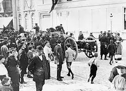 Soldats belges et artillerie sur la place d'armes de Gand, après la retraite de Termonde, le 9 septembre 1914. Des civils regardent.