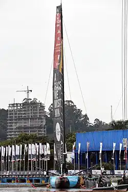 Voilier vu de face, amarré au ponton, grand-voile hissée.