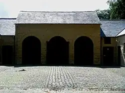 Cour pavée de galets en arête-de-poisson.