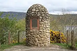 Photo d'un mémorial en pierre avec une plaque en métal apposée dessus.