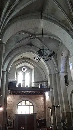 La nef vers l'entrée avec une première travée courte voûtée en berceau qui porte le clocher et une deuxième travée voûtée d'une croisée d'ogives.