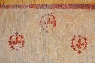 Fleurs de lys peintes sur un mur de la chapelle.