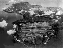 Photos en noir et blanc d'une base militaire de grande envergure en bord de mer.