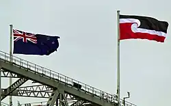 The tino rangatiratanga flag and New Zealand flag flying on Auckland Harbour Bridge