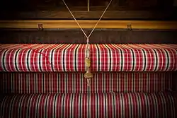 Le cordon actionne le chasse-navette, qui fait passer la navette d'un côté à l'autre du métier.