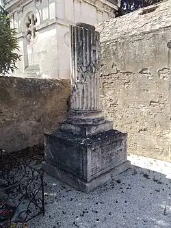 Tombeau pilier en pierre blanche, à l'arrière chapelle de calcaire.