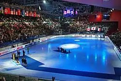 La patinoire, avec un podium, éclairée par une lumière bleue.