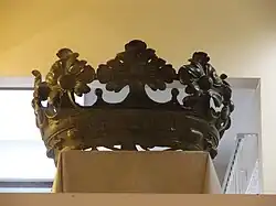 Photographie en couleurs d'une couronne derrière une vitrine.