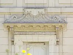 Photographie en couleurs du linteau en pierre gravée d'une porte.