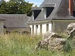 Photographie en couleurs d'un bâtiment à rez-de-chaussée et combles.