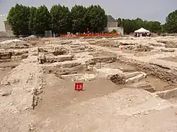Photographie en couleurs de plusieurs sarcophages dans le sol d'un ancien bâtiment.